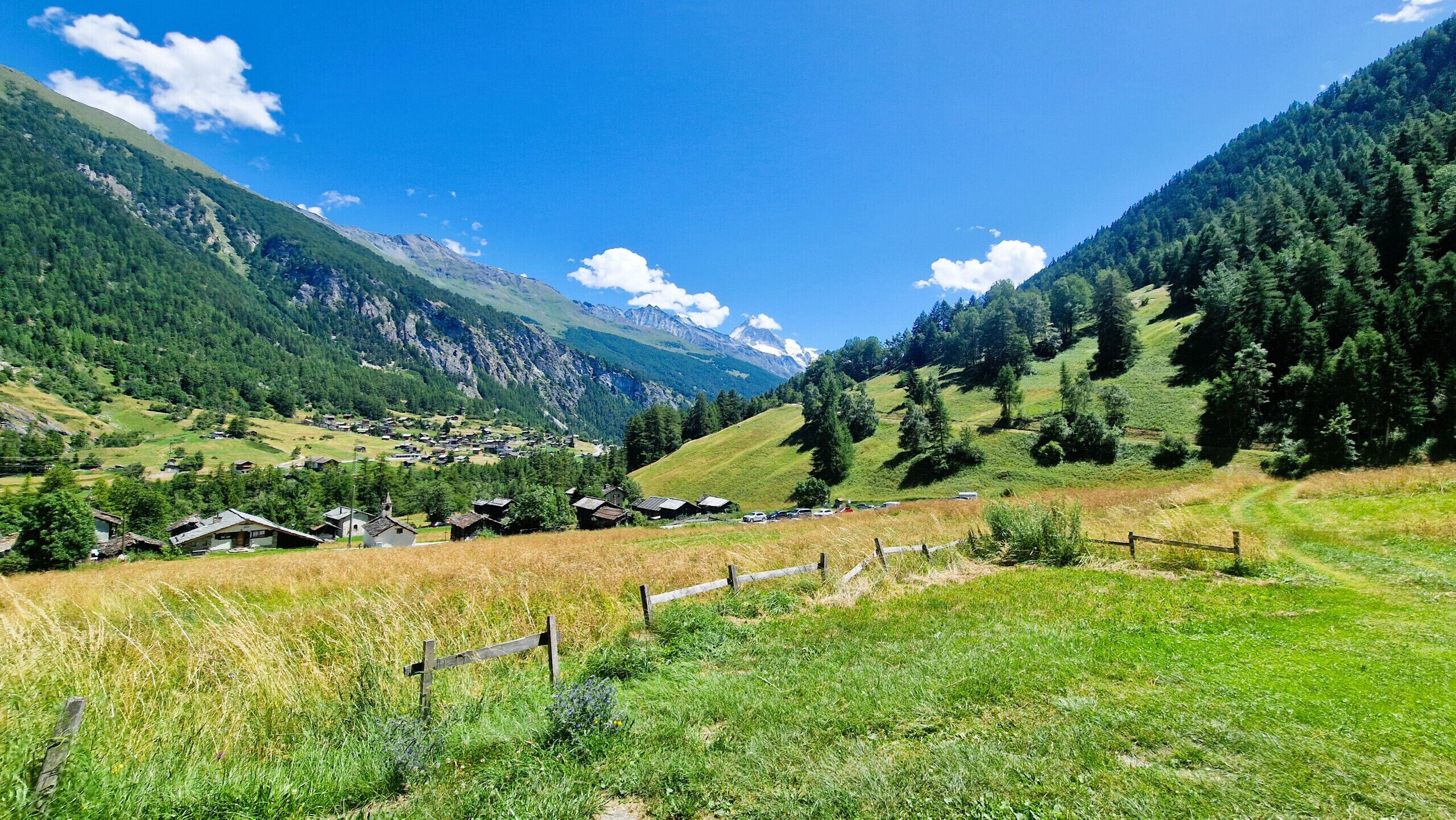 Un pueblo rural con casas y una montaña al fondo.