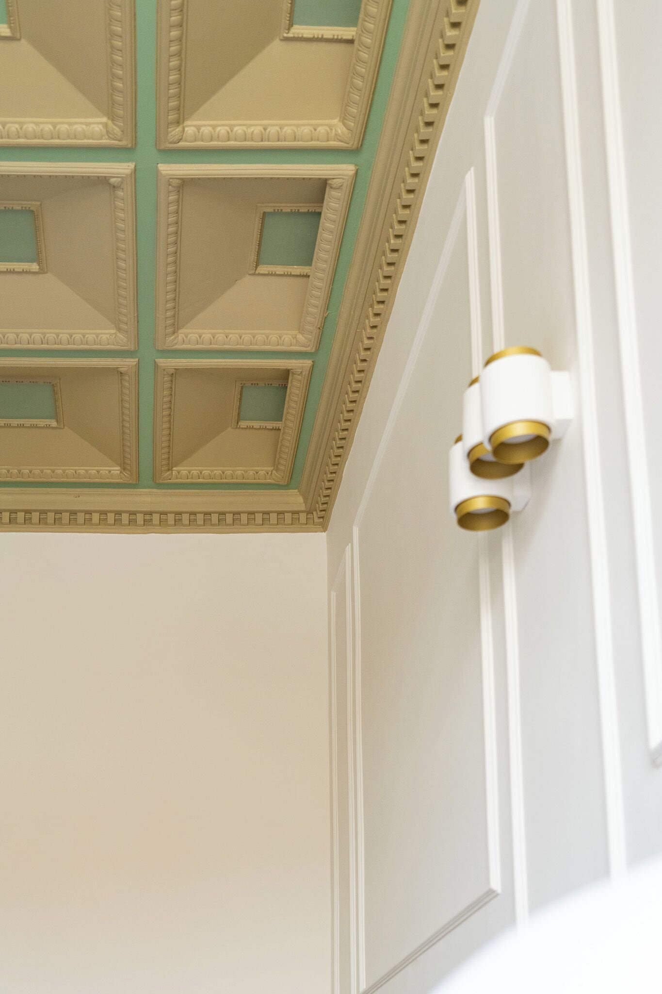 Et loft med et geometrisk mønster og en vægmonteret lampe.