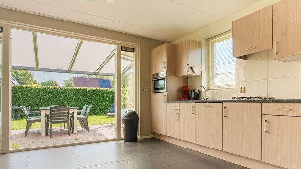 A modern kitchen with sliding glass doors leading to an outdoor patio area.