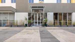 A modern building with a glass entrance, potted plants, and a number '300' sign. - Beautiful studio in São Caetano Ap610 (São Caetano do Sul)