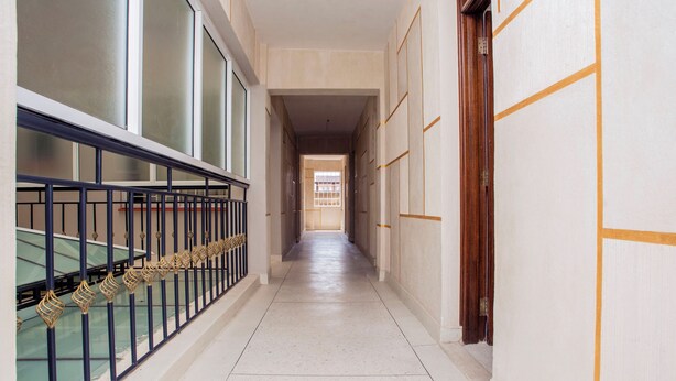 En lång, smal hall med ett glasräcke på ena sidan och en trädörr på den andra.