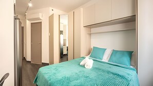 A hotel room with a bed, a wardrobe, and a bathroom visible through an open door. - Beautiful Studio São Caetano Barcelona ap412 (São Caetano do Sul)