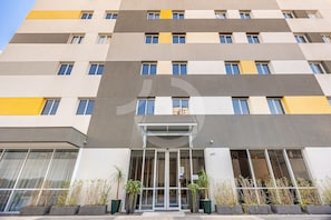 A multi-story building with a modern facade, large windows, and a central entrance with glass doors.