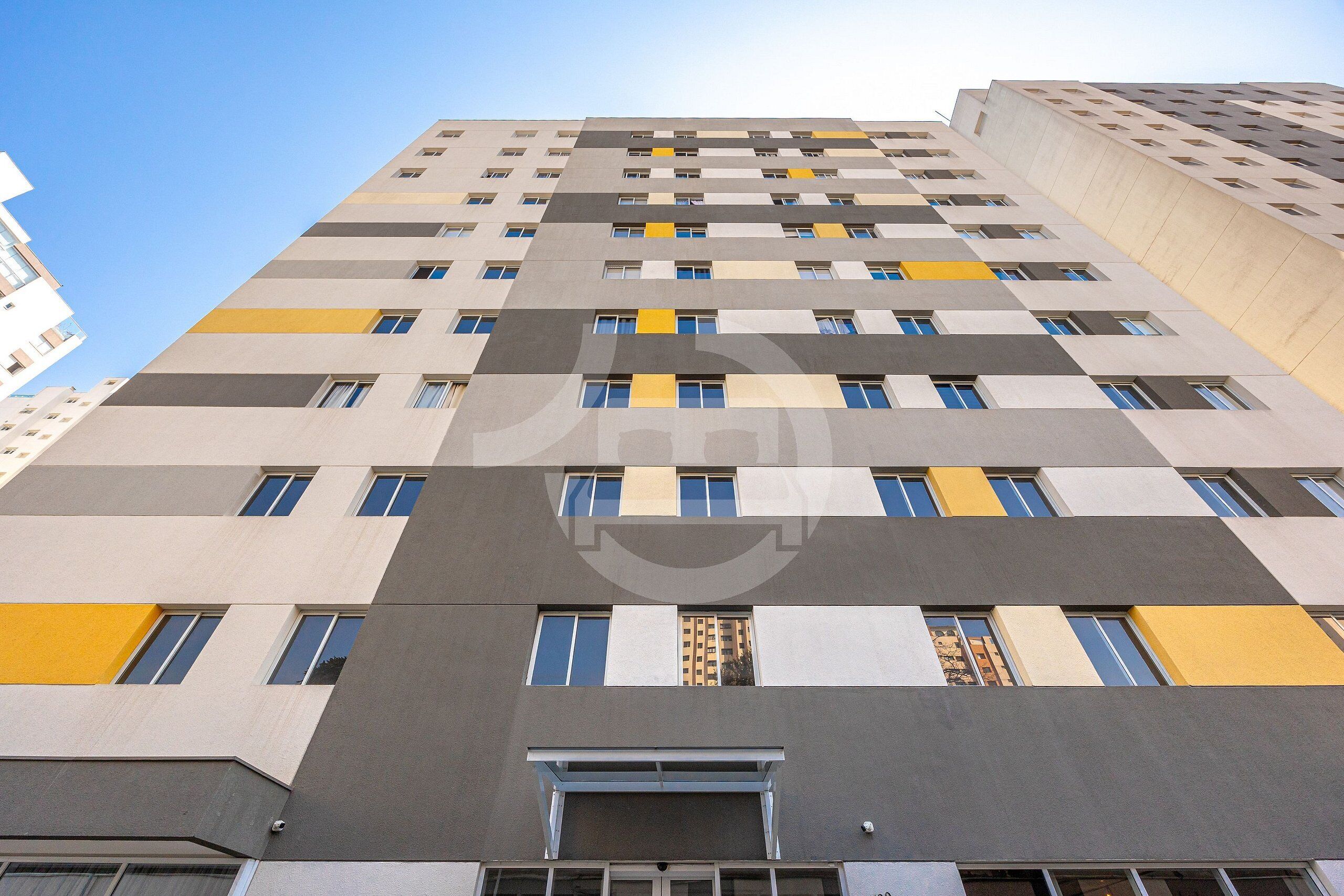 A multi-story building with a modern architectural design, featuring a series of windows and balconies.