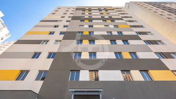 A multi-story building with a modern architectural design, featuring a series of windows and balconies.