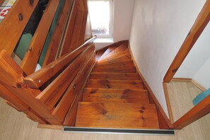 Eine Holztreppe mit Handlauf, die zu einer oberen Etage führt.