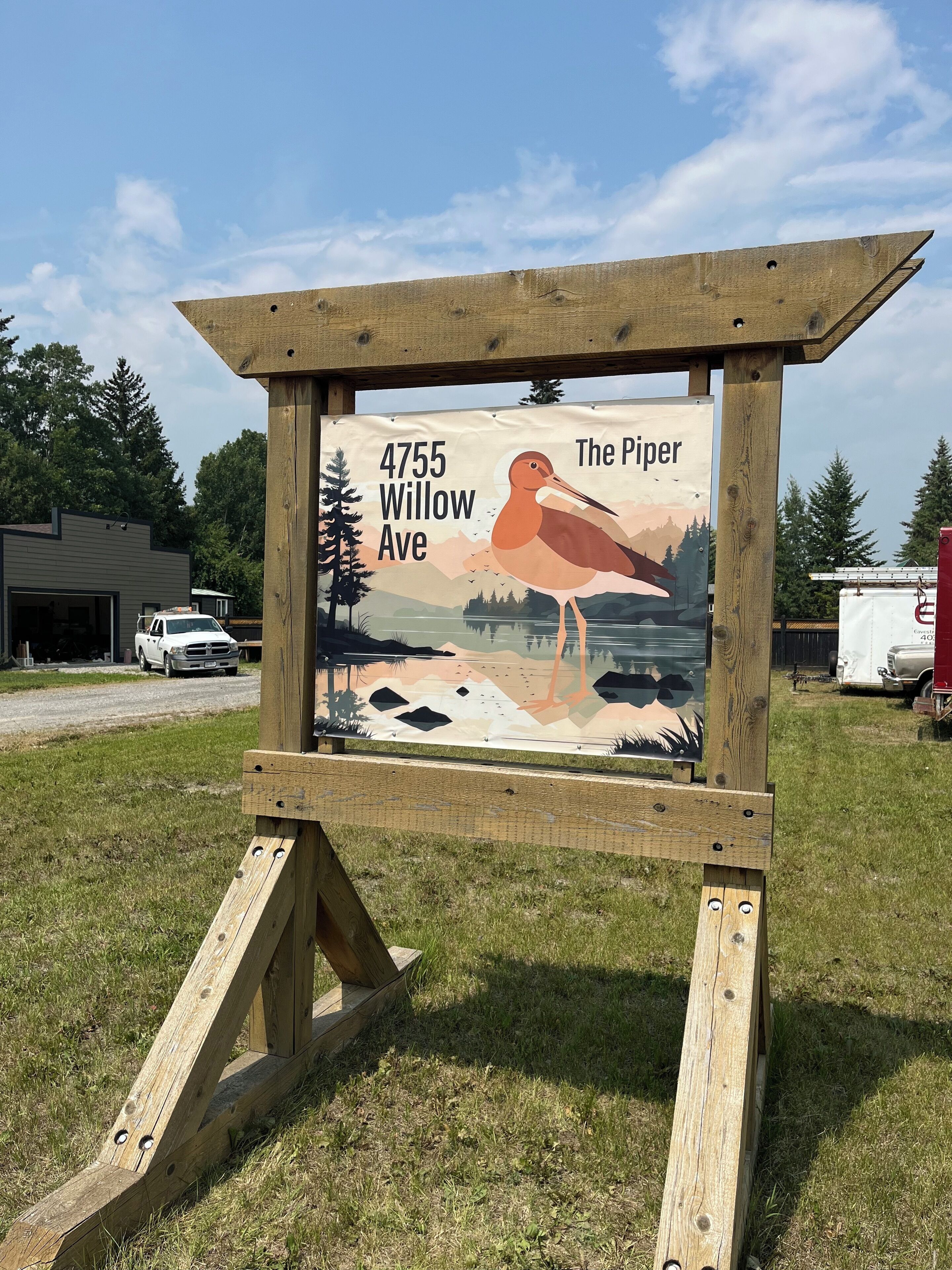 A wooden sign with a bird illustration and text indicating '4755 Willow Ave' and 'The Piper'.