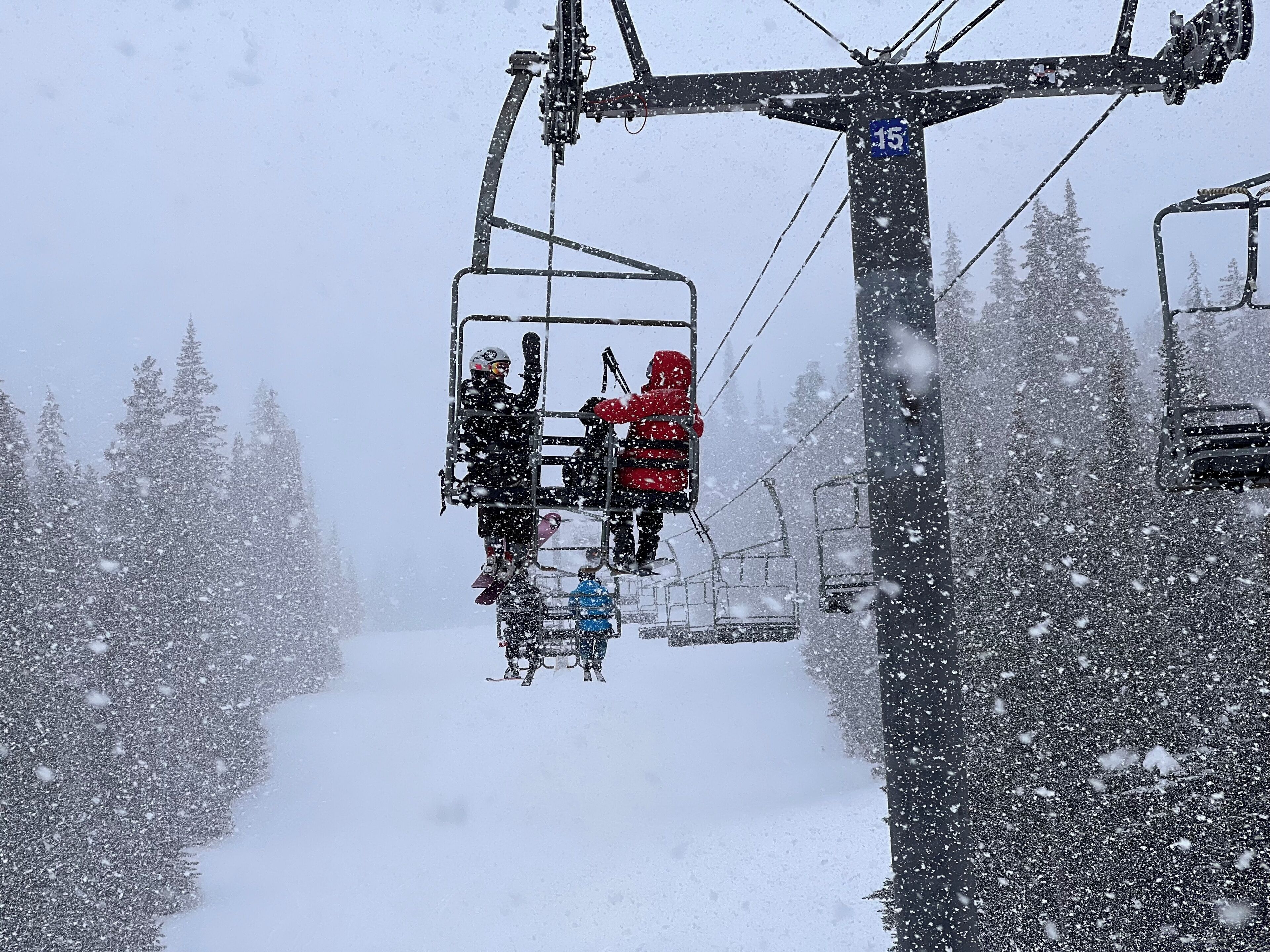 Eine Seilbahn mit Fahrgästen, umgeben von schneebedeckten Bäumen.