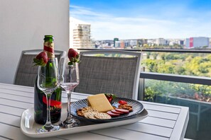 Ein Tisch mit einer Champagnerflasche, zwei Gläsern, einer Käseplatte, Erdbeeren, Mandeln und Crackern.