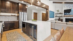 Une cuisine moderne avec des meubles en bois foncé, des appareils électroménagers en acier inoxydable et un îlot central en marbre.
