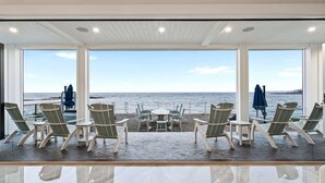 A beachside lounge with a view of the sea, featuring lounge chairs and umbrellas. - Brand New Home Ocean Views Wolf Appliances (Wells)