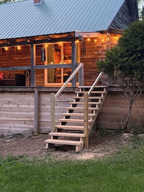 Une cabane en bois avec un escalier menant à une véranda.
