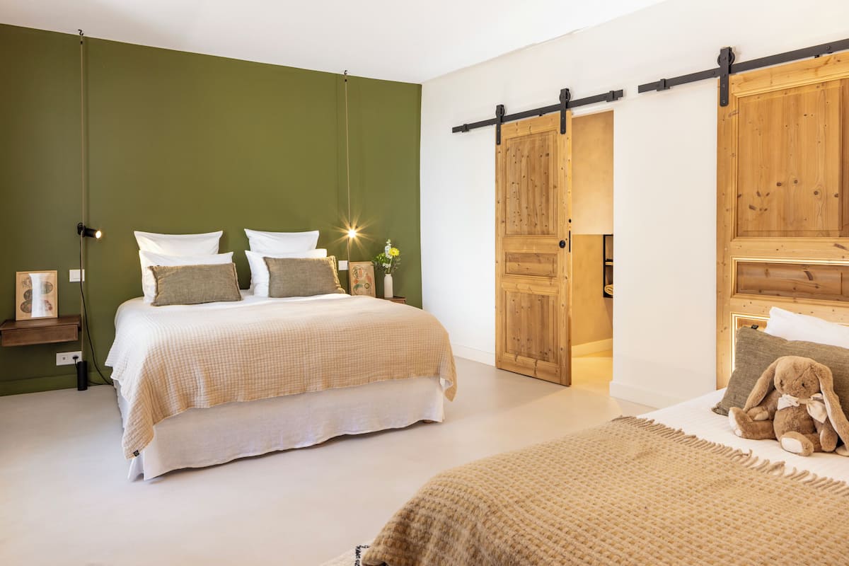 Un dormitorio con cama, mesitas de noche, cómoda y una puerta corrediza tipo granero.