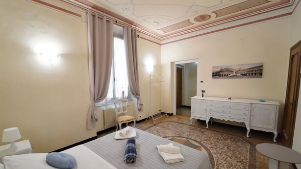 A hotel room with a bed, a desk, a chair, a dresser, and a painting on the wall. - Genova Principe Suite (Genoa)