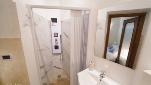 A modern bathroom with a marble shower, a white sink, and a mirror. - Genova Principe Suite (Genoa)