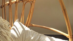 A wicker chair with a cushion and a macramé throw. - Romantic Studio with Sunlight in the City Center (Hồ Chí Minh)