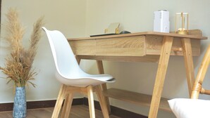 A wooden desk with a white chair, a vase with dried plants, and a lamp. - Romantic Studio with Sunlight in the City Center (Hồ Chí Minh)