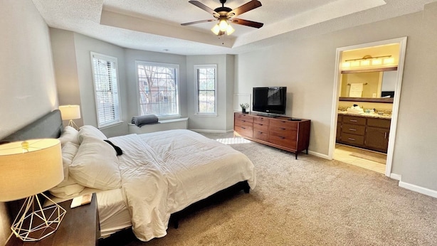 A bedroom with a bed, a dresser, a TV, and a ceiling fan. - 4 Bedroom Family Friendly Home in Great Madison Location (Madison)