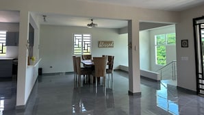 Un interior amplio y luminoso con comedor, cocina y una escalera que sube a un nivel superior.