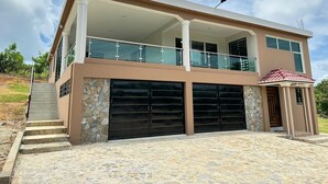 Una casa de dos pisos con balcón, garaje y fachada de piedra.
