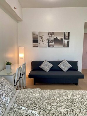 Escritorio, tabla de planchar con plancha, wifi y ropa de cama