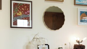 A living room with a white sofa, a wooden console table with decorative items, and framed artwork on the wall.