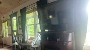 A living room with a fireplace, a television, and a dining area. - Fisherman’s paradise waterfront. Boat ramp on property sleeps 6.      2-2.  (Many)