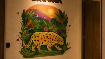 A wall with a mural of a jaguar and tropical plants, labeled 'JAGUAR' and 'LLANOS ORIENTALES'.