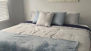 A bedroom with a bed, pillows, and a blanket. - Oceanside, Duplex - 1st Flr Unit North Beach Haven, 20th St (Long Beach)