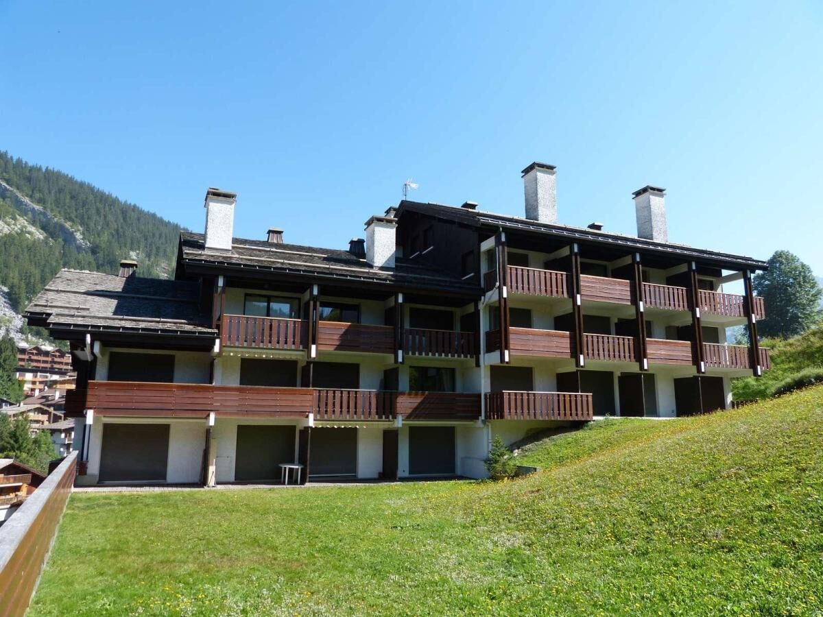 Un immeuble à plusieurs étages, doté de balcons, d’un toit en pente et de cheminées.