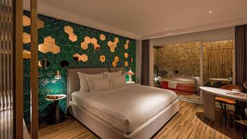 Une chambre d’hôtel moderne avec un grand lit, un bureau et un mur en pierre.