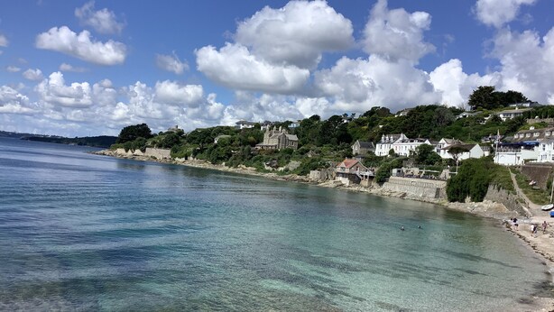 A coastal town with clear waters, a sandy beach, and buildings along the shore. - Sail Loft (Marine Parade - St Mawes) (St Mawes)
