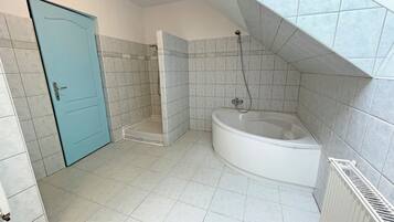 Une salle de bain avec une baignoire, une douche et une porte bleue.