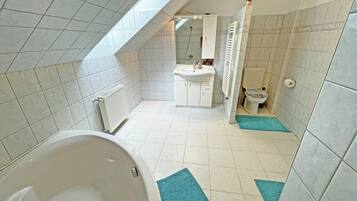 Un baño moderno con bañera, lavamanos e inodoro.