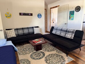 A living room with a sofa, a coffee table, and a patterned rug.