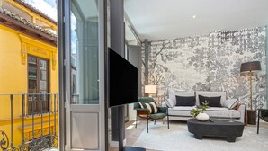 A living room with a sofa, coffee table, and a flat-screen TV. - Genteel Home San Matías III (Granada)