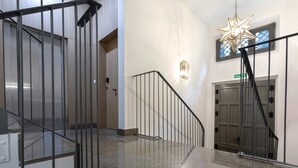 Ein stilvolles Interieur mit einer Treppe, einer sternförmigen Leuchte und einer Tür mit der Aufschrift 'SALON'.