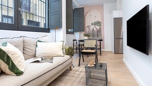 Ein modernes Wohnzimmer mit einer Couch, einem Couchtisch und einem Fernseher.