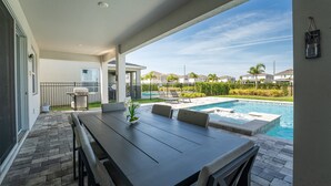 A patio with a pool, outdoor furniture, and a view of neighboring houses. - Discover Your Inner Child  Encore Villa (Kissimmee)