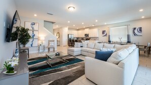 A spacious living area with a sectional sofa, a coffee table, and a dining area with a table and chairs. - Discover Your Inner Child  Encore Villa (Kissimmee)