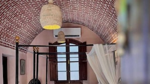 A four-poster bed with a canopy, a wooden nightstand, and a window with wooden shutters. - El Juneina Villas - Luxury Boutique Villas Near Valley of the Kings (Luxor)