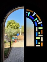 Vista a través de un vano con una ventana de vitral.