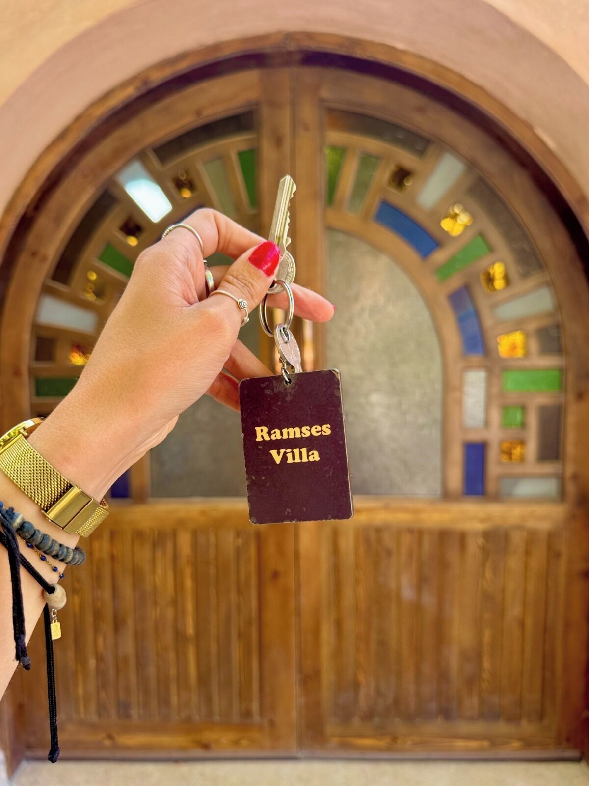 A hand holding a keychain with a tag labeled "Ramses Villa."