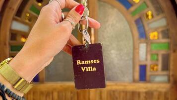 A hand holding a keychain with a tag labeled "Ramses Villa."