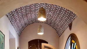 A hallway with a wooden bench, a table, and a door with colorful stained glass. - El Juneina Villas - Luxury Boutique Villas Near Valley of the Kings (Luxor)