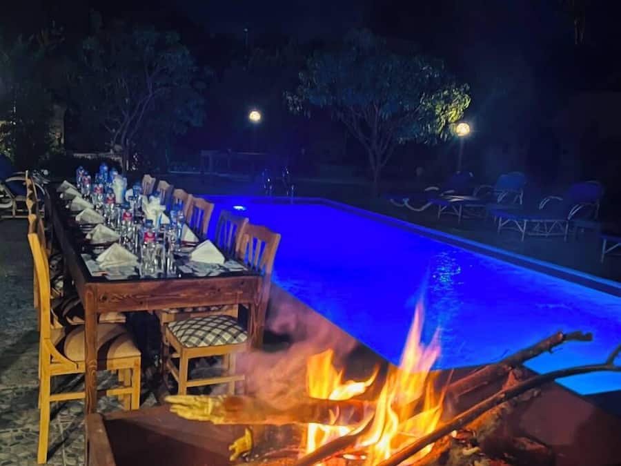 An outdoor dining area with a pool and a fire pit.
