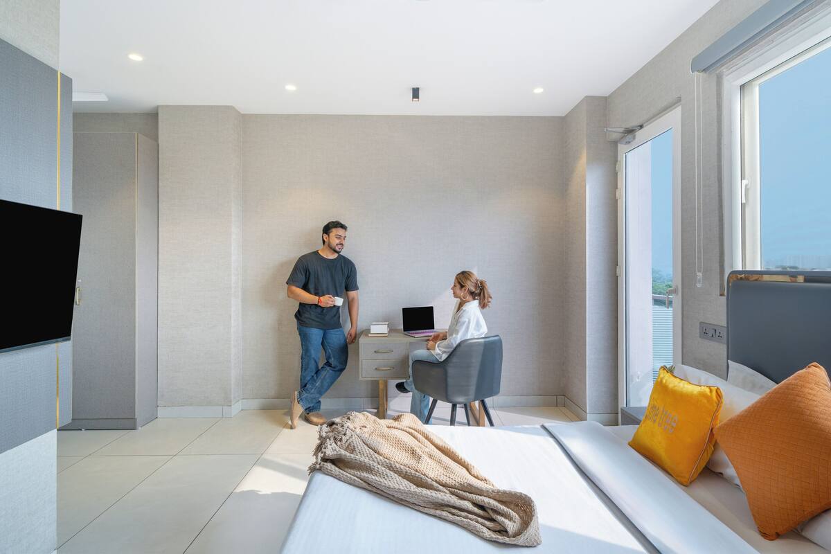Ein modernes Hotelzimmer mit Bett, Schreibtisch und großem Fenster.