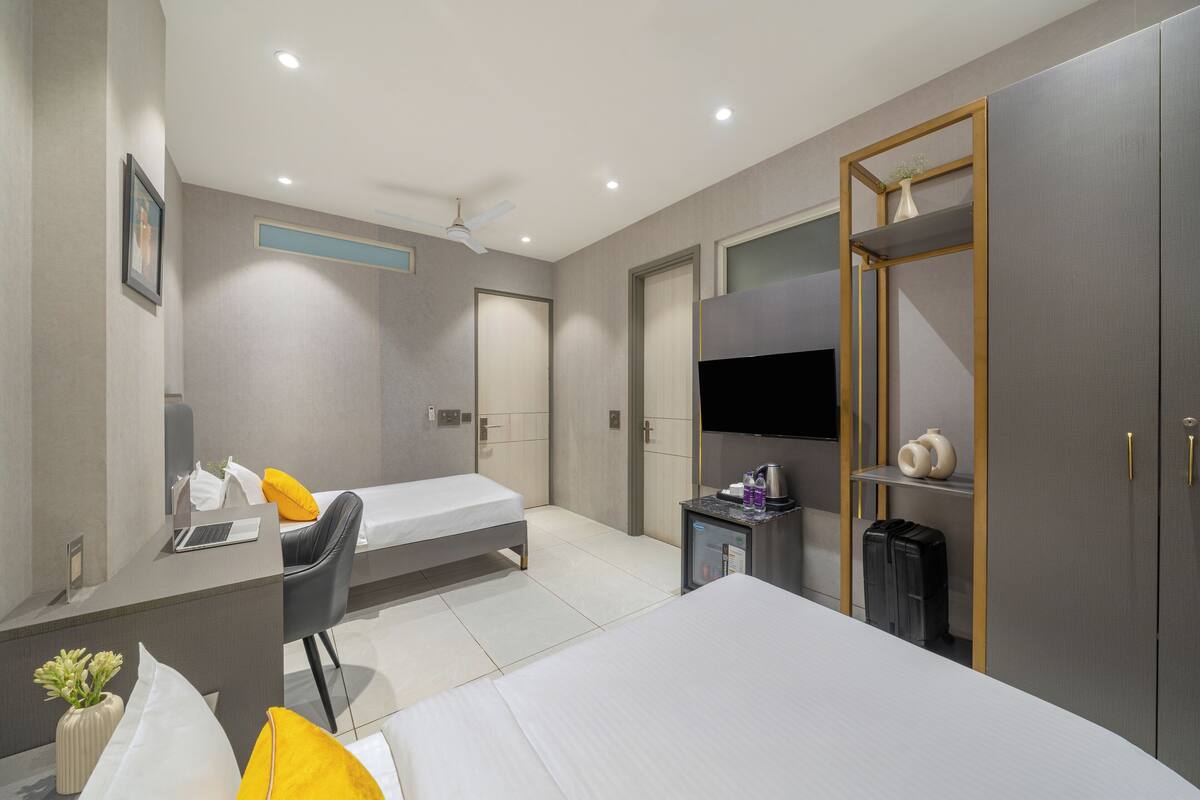 Ein modernes Hotelzimmer mit Bett, Schreibtisch, Stuhl und Fernseher.