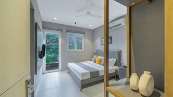 Un dormitorio moderno con cama, mesitas de noche, espejo y vistas a zonas verdes.