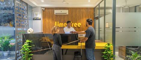 A reception desk with a wooden panel background and a sign that reads "Lime Tree."